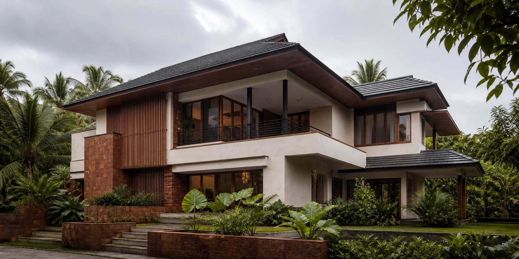 Contemporary Kerala villa with laterite stone and deep monsoon-ready roof overhangs
